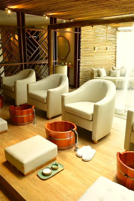Poltronas do spa com bacias de madeira para o escalda-pés