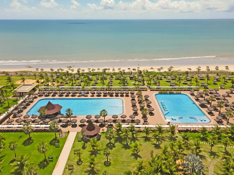 Vista aérea do Vila Galé Touros, com as piscinas entre coqueiros e o mar ao fundo